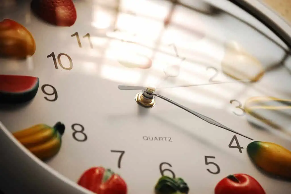 Eine Uhr, geschmückt mit einer Reihe bunter Früchte und Gemüse.