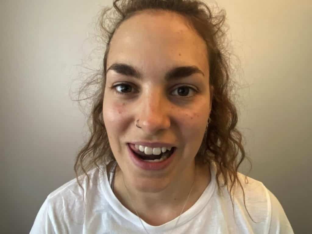 Eine junge Frau mit einem Lächeln im Gesicht, spezialisiert auf Sportosteopathie.