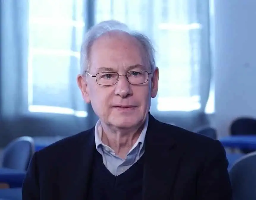 Ein älterer Mann mit Brille sitzt in einem Zimmer und lässt sich von Osteopathen Hamburg sanft behandeln.