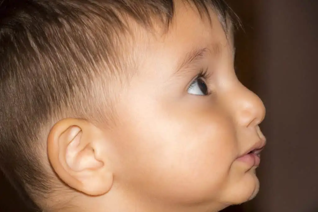 Eine Nahaufnahme eines kleinen Jungen mit Sportosteopathie, der nach oben schaut.