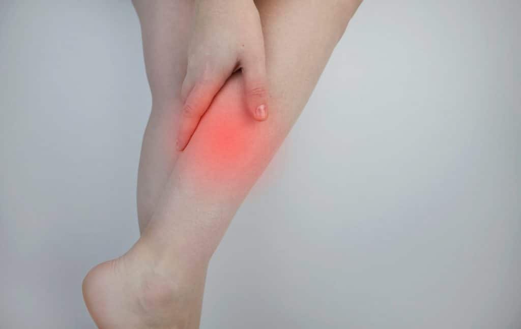 Eine Frau, die Linderung von Beinschmerzen sucht und sich insbesondere für osteopathische Behandlungsmöglichkeiten in Hamburg interessiert.