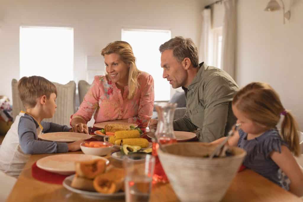 Una famiglia si riunisce intorno a un tavolo e consuma un pasto insieme.
