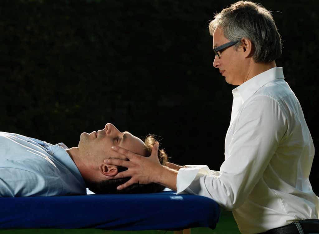Ein Mann erhält eine Kopfmassage von einem Osteopathen in Hamburg.