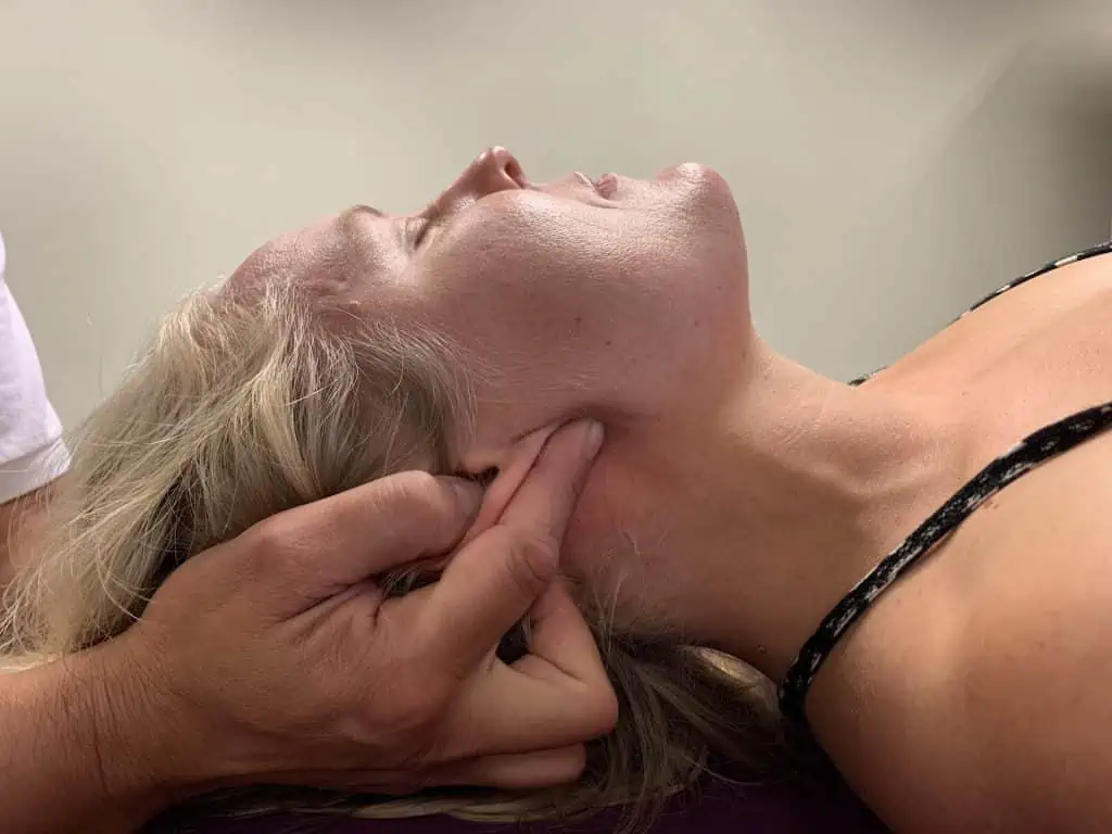 Eine Frau unterzieht sich einer entspannenden Nackenmassage bei einem Osteopathen in Hamburg.