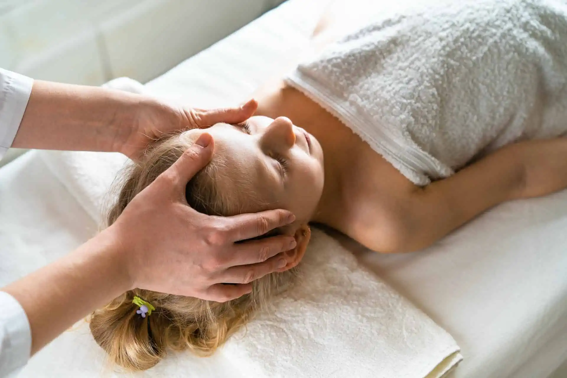 Ein junges Mädchen erhält eine Massage in einem auf Kinderosteopathie spezialisierten Spa.