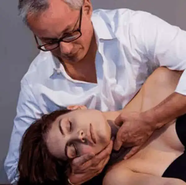 Ein Mann, der sich mit Osteopathie auskennt, gibt einer Frau eine Nackenmassage.