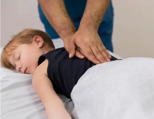 Ein kleiner Junge erhält von einem Arzt Kinderosteopathie.