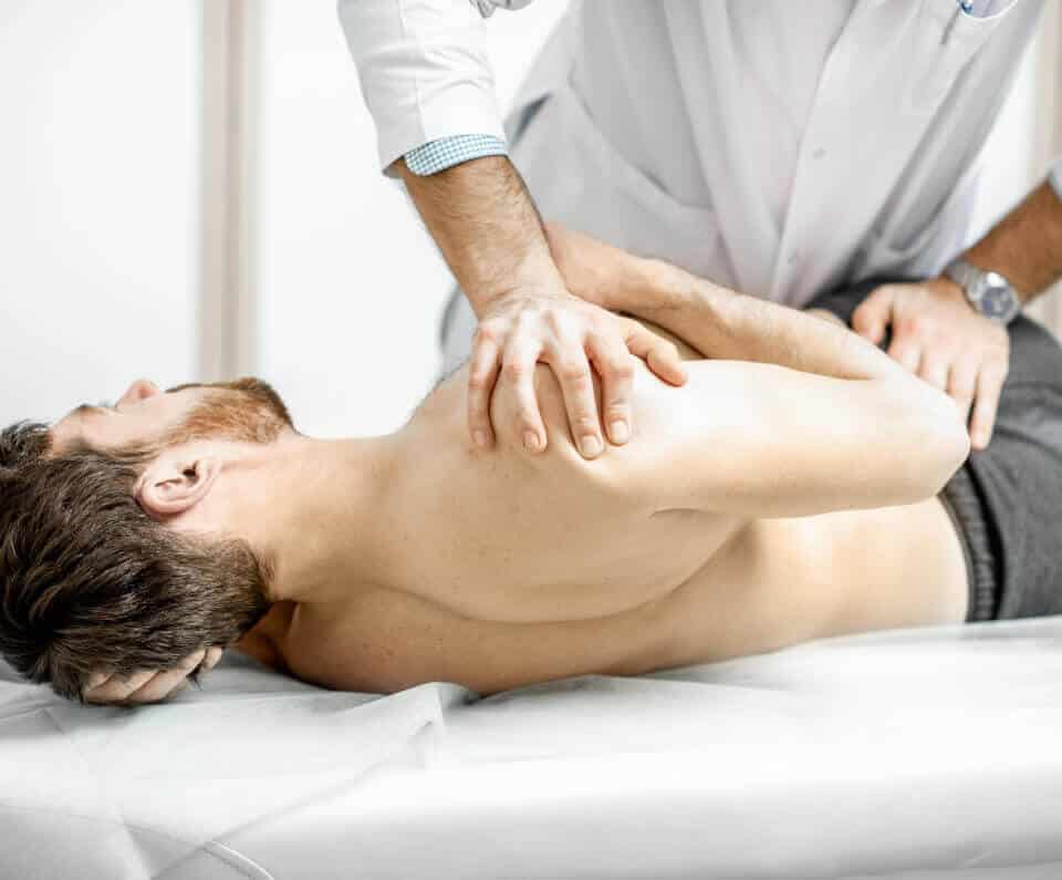 A man receives a back massage from an osteopath in Hamburg.