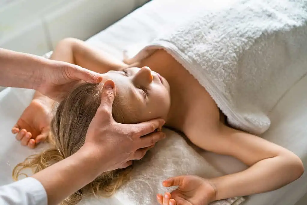 Ein junges Mädchen erhält eine wohltuende Massage in einem Spa in Hamburg.