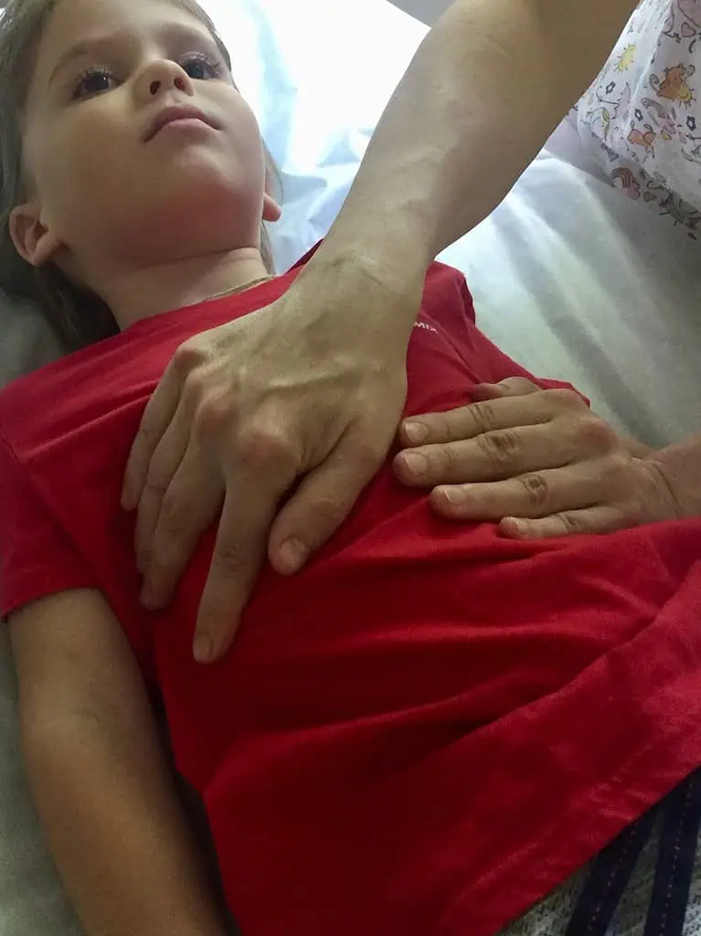 Ein kleiner Junge wird auf einem Bett in Hamburg osteopathisch betreut.