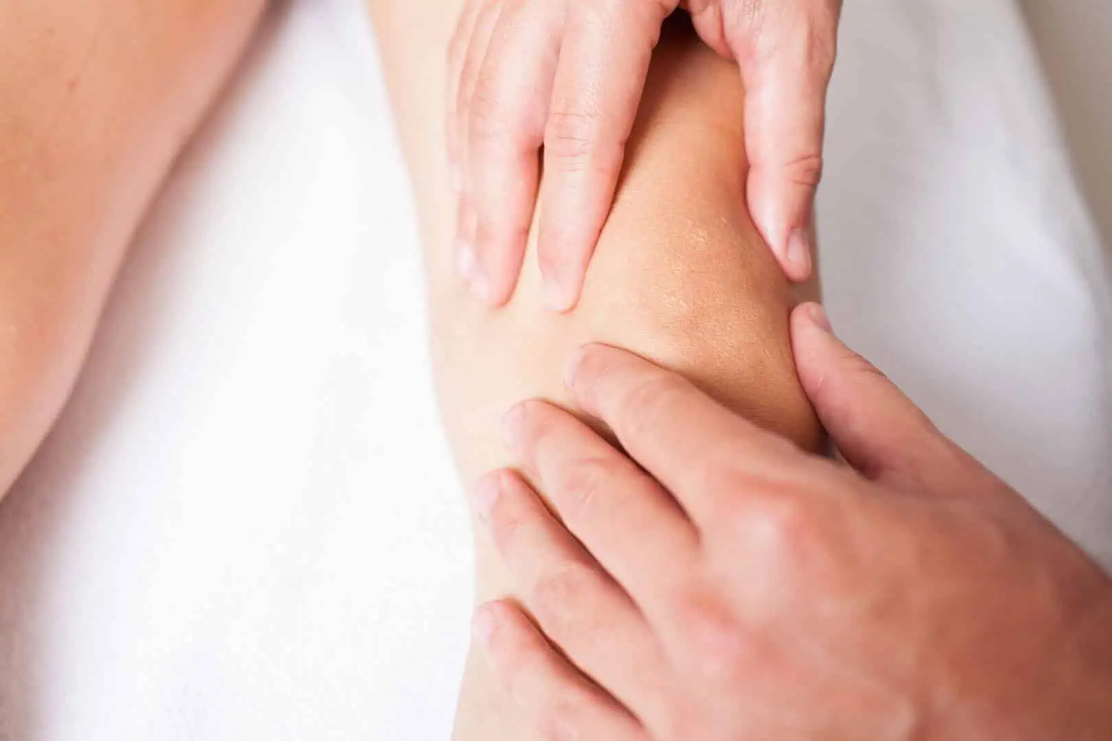 Eine Frau erhält in Hamburg eine sportosteopathische Kniemassage.