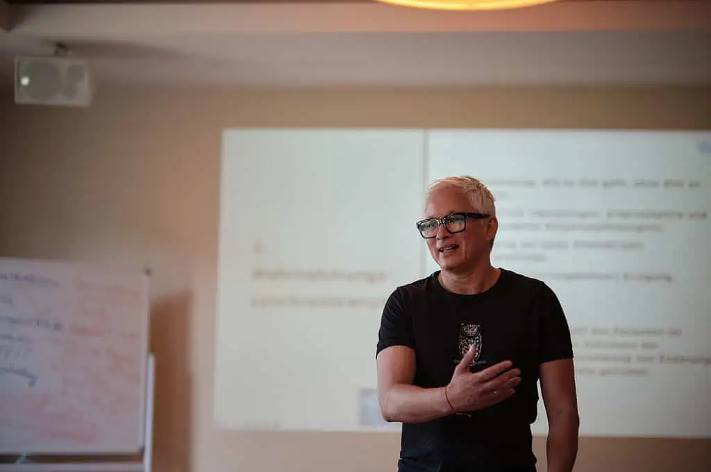 Ein Mann hält vor einem Bildschirm einen Vortrag über Osteopath Hamburg.