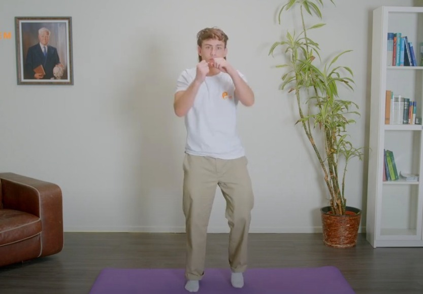 Ein fitter Mann, der in einem Wohnzimmer Yoga macht.